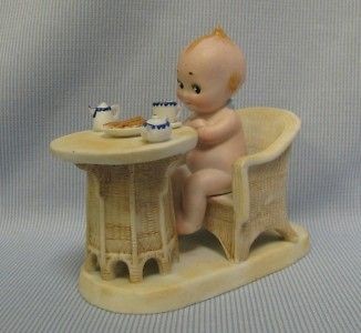   Neill Kewpie on platform with Wicker Chair & Table Having Breakfast